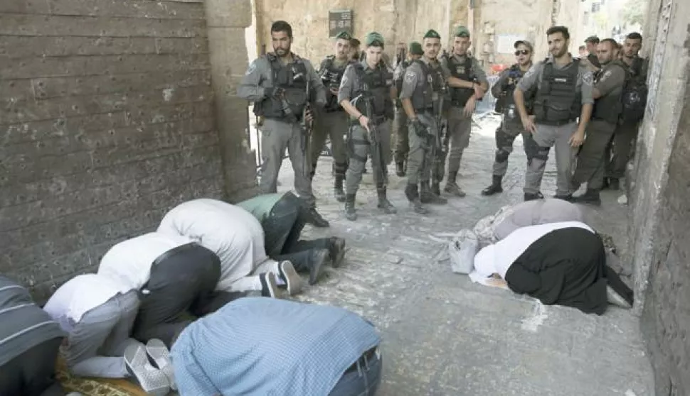 epa06108355 Israeli border police on duty as Palestinians pray at the Lion's Gate in the Old City of Jerusalem near the entrance to the Haram el-Sherif (Noble Sanctuary), or The Temple Mount to Jews, at the Old City of Jerusalem, 25 July 2017. During the night police removed the controversial metal detectors that were placed in the wake of a shooting of two Israeli police officers at this popular entrance to the Al-Aqsa Mosque, amid a diplomatic easing of recent tensions. The mufti of Jerusalem called on Muslims not to enter and pray at the Al-Aqsa Mosque, even though Israel had been dismantled metal detectors EPA/ABIR SULTAN