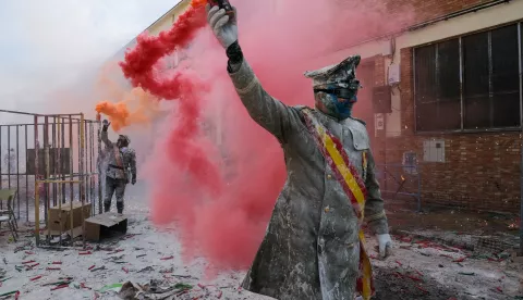 epa11795755 People covered in flour hold flares as people celebrate the traditional fest called 'The floured ones' (Els Enfarinats) in Ibi, Alicante, Valencia, Spain, 28 December 2024. The fest is celebrated during the 'Dia de los Santos Inocentes' (Saint Innocents Day), the Spanish version of April Fools' Day, and people battle among themselves with fireworks, flour and eggs. EPA/PABLO MIRANZO