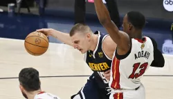 epa10673839 Denver Nuggets center Nikola Jokic of Serbia (C) drives past Miami Heat center Bam Adebayo (R) during the third quarter of game two of the NBA Finals between the Miami Heat and the Denver Nuggets at Ball Arena in Denver, Colorado, USA, 04 June 2023. EPA/BOB PEARSON SHUTTERSTOCK OUT