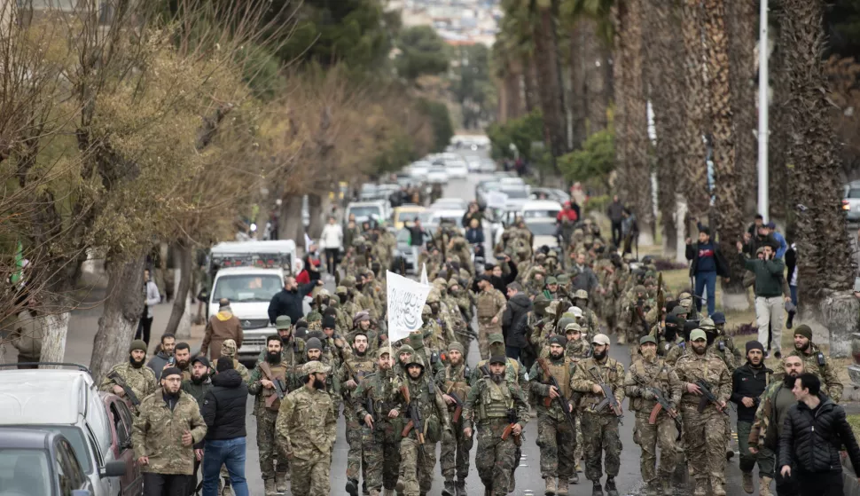 epa11794980 Syrian opposition fighters march during a military parade in Damascus, Syria, 27 December 2024. Members of Hay'at Tahrir al-Sham (HTS) began marching from abbasieen Square, passing through some of the Damascene neighborhoods, and arrived at Umayyad Square in a parade organized to send a message of strength and reassurance to the people, according to HTS.