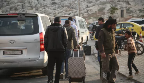 epa11770718 Syrians walk with their belongings after arriving from Turkey through the Bab al-Hawa border crossing, north of Idlib, Syria, 11 December 2024. According to media relations for the Bab al-Hawa border crossing, more than 2,500 Syrians crossed from Turkey over the past three days, following the ousting of Syrian President Bashar al-Assad on 08 December. EPA/BILAL AL HAMMOUD