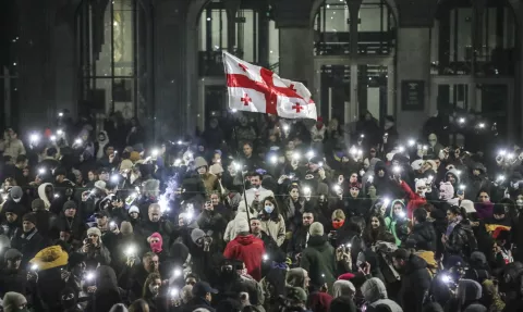 epa11760932 Supporters of the Georgian opposition hold a Georgian flag during a protest in front of the Parliament building in Tbilisi, Georgia, 06 December 2024. Thousands of pro-EU activists continue their protests in the Georgian capital against the country's ruling party decision to suspend accession talks with the European Union (EU) until the end of 2028. EPA/DAVID MDZINARISHVILI