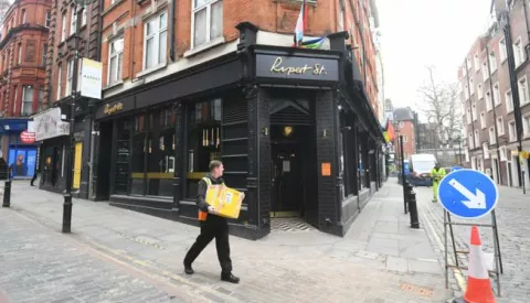 epa09046406 A man walks past a pub in Soho in London, Britain 02 March 2021. Britain's Chancellor of the Exchequer Rishi Sunak will deliver his budget on 03 March 2021. His statement to MPs in the House of Commons outlines the state of the economy and the government's plans for raising or lowering taxes. It also includes forecasts for how the UK economy could perform in future. EPA/FACUNDO ARRIZABALAGA