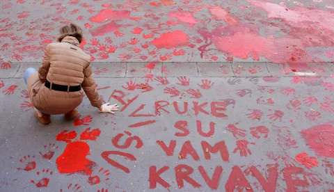 epa11751325 A protestor paints the pavement with red paint symbolizing blood during the one month anniversary of the Novi Sad train station accident in Novi Sad, Serbia, 01 December 2024. Fifteen people lost their lives in the collapse of the Novi Sad Railway Station canopy on 01 November 2024. The station building, which had been renovated and reopened on 05 July 2024, was undergoing further renovations shortly before the collapse. EPA/ANDREJ CUKIC