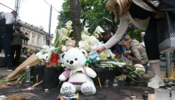 epa10608076 People leave flowers and light candles for the victims in front of the "Vladislav Ribnikar" elementary school in Belgrade, Serbia, 04 May 2023. A teenage student fatally shot seven girls and one boy using two handguns, which he had taken from his father. Six children and a teacher were also injured in the attack. EPA/ANDREJ CUKIC