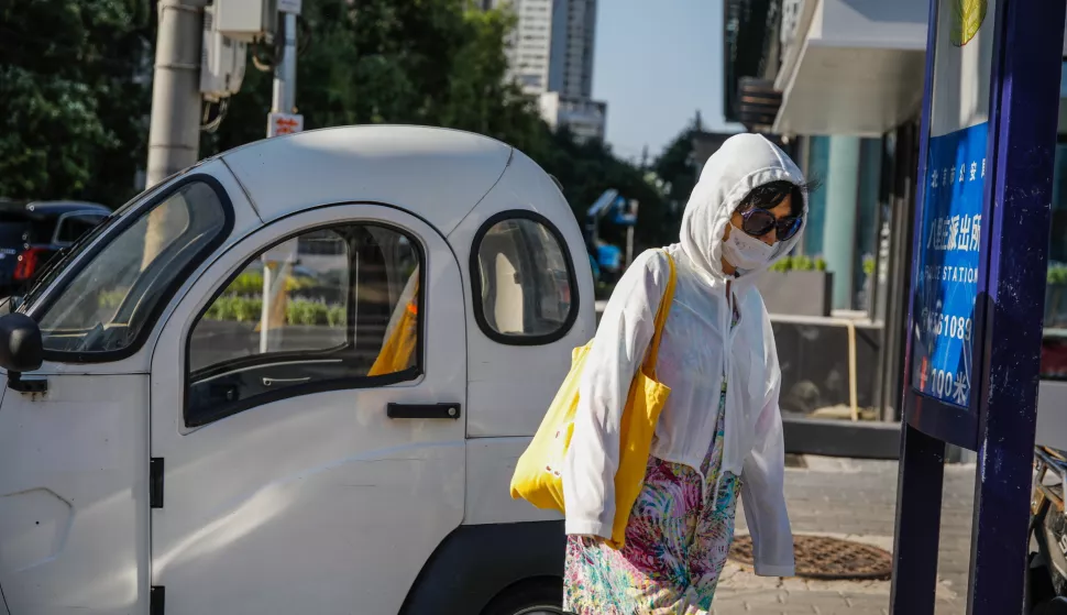 epa10811387 A woman wearing a face mask walks on a street in Beijing, China, 21 August 2023. The EG.5 substrain of the Omicron variant has became the most prominent source of COVID-19 infections across China, as the number of infections caused by EG.5 has risen to 71.6 percent in August from just 0.6 percent in the month previously, said the Chinese Center for Disease Control and Prevention on 19 August. EPA/WU HAO