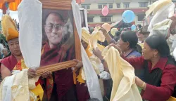 epa000474522 A group of Tibetans cheer infront of a portrait of the Dalai Lama during celebrations marking the Dalai Lama's 70th birthday at Namgyal School in Sitapaila, on the outskirt of the Kathmandu, Nepal on Wednesday. 06 July 2005. More than 5.000 Tibetans and monks gathered at the school compound to celebrate their spiritual leader's birthday, due to government prevention at the sacred place of Bouddhanath Stupa. EPA/NARENDRA SHRESTHA