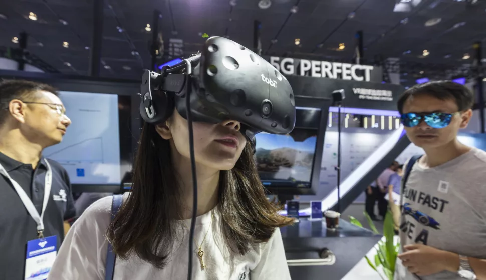 epa07029257 A woman uses a VR goggles (virtual reality headset) with 5G technology at the World Internet of Things (WIoT) exposition in Wuxi, Jiangsu Province, China, 15 September 2018. EPA/ALEKSANDAR PLAVEVSKI