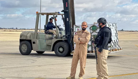 epa11798983 A Qatari officer (L) chats with an opposition fighter as Syrian officials unload the aid from a Qatari aircraft at Damascus International Airport, in Damascus, Syria, 30 December 2024. A Qatari Armed Forces aircraft carrying humanitarian aid including ambulances, food supplies and medicines provided by the Qatar Development Fund, and technical assistance to help restart the Syrian capital's airport landed in Damascus on 30 December as part of Qatar's air bridge to provide relief to Syria, according to the Qatari Foreign Ministry. EPA/MOHAMMED AL RIFAI