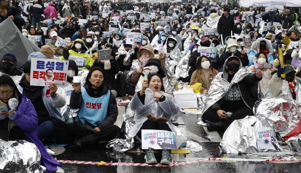 epa11806672 Members of the Korean Confederation of Trade Unions (KCTU) shout slogans during a rally against impeached president Yoon Suk Yeol, near the presidential residence in Seoul, South Korea, 05 January 2025. A Seoul court on 31 December 2024 issued an arrest and search warrant to detain impeached president Yoon over his short-lived imposition of martial law. The Corruption Investigation Office (CIO) on 03 January suspended the execution of the arrest warrant and announced that its investigators were leaving the presidential residence after a standoff with the Presidential Security Service (PSS). EPA/JEON HEON-KYUN