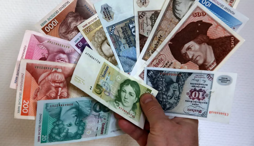 Deutschmarks are held up at a branch of the German Central Bank in Rostock, Germany, 23 December 2013. Every year in Germany, millions worth of Deutschmarks are still being exchanged for euros. Photo: Bernd Wuestneck/DPA/PIXSELL