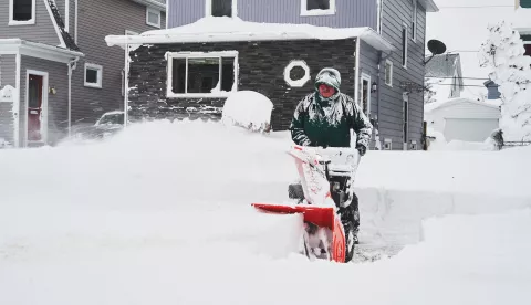 epa10378181 A man uses a snowplow to clear his driveway as the effects of a massive winter storm which has affected large portions of the United States, continues in Buffalo, New York, USA, 25 December 2022. Much of the United States is currently experiencing some sort of winter weather as a result of the large storm which was generated by a bomb cyclone, the meteorological phenomenon when the atmospheric pressure quickly drops in a strong storm EPA/JOSH THERMIDOR