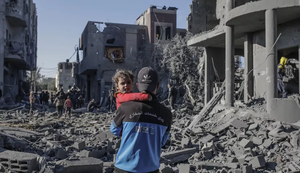 epa11803411 A Palestinian father carries his daughter next to the destroyed house of the Abu Libda family following an Israeli air strike in Al Maghazi refugee camp, central Gaza Strip, 03 January 2025. According to reports from the Ministry of Health in Gaza at least nine members of the Abu Libda family were killed following an Israeli air strike in the refugee camp. More than 45,500 Palestinians and over 1,400 Israelis have been killed, according to the Palestinian Health Ministry and the Israeli Army, since Hamas militants launched an attack against Israel from the Gaza Strip on 07 October 2023 and the Israeli operations in Gaza and the West Bank that followed it. EPA/MOHAMMED SABER