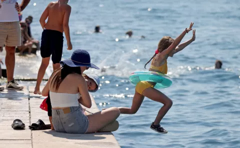 Zadar, 24.08.2024. - Turisti uživali u šetnji starom gradskom jezgrom a neki su osvježenje pronašli u moru na zadarskoj rivi.Foto HINA/Zvonko KUCELIN