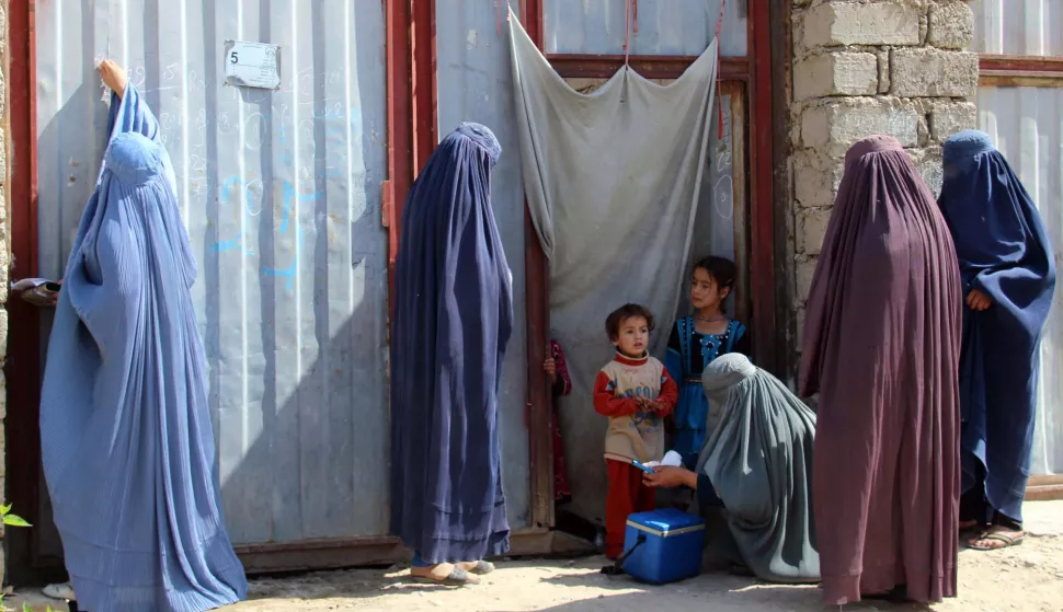 epa07143299 Afghan women visit a village to administer Polio vaccination to children, in Helmand, Afghanistan, 05 November 2018. Afghanistan is one of the two countries along with neighboring Pakistan where polio is still endemic, crippling hundreds of children every year. EPA/WATAN YAR