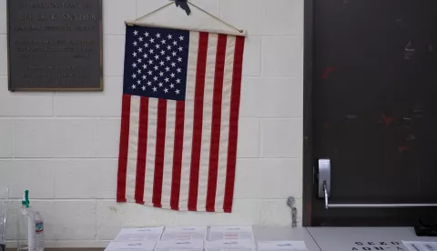 epa10294949 An American flag hangs above ballots at the Boyle Heights Senior Center in Los Angeles, California, USA, 08 November 2022. The US midterm elections are held every four years at the midpoint of each presidential term and this year include elections for all 435 seats in the House of Representatives, 35 of the 100 seats in the Senate and 36 of the 50 state governors as well as numerous other local seats and ballot issues. EPA/ALLISON DINNER