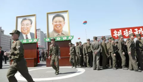 epa05905507 North Korean soldiers march beside portraits of former supreme leader Kim Il-sung and Kim Jong-il after an opening ceremony for a new residential housing project on Ryu Myong street in Pyongyang, North Korea, 13 April 2017. North Korean leader Kim Jong-un presided over the opening of a new residential housing project amid much fanfare, as tensions rise over over nuclear issues in the region. EPA/HOW HWEE YOUNG