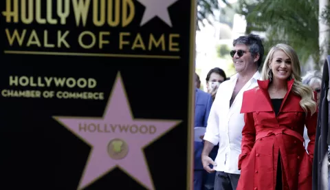 epa07036004 UK producer Simon Cowell (L) and US singer Carrie Underwood (R) wait off stage during a ceremony honoring her with a star on the Hollywood Walk of Fame in Hollywood, California, USA, 20 September 2018. Underwood received the 2,646th star in the Recording category. EPA/MIKE NELSON