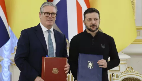 epa11828599 Ukrainian President Volodymyr Zelensky (R) and British Prime Minister Keir Starmer (L) pose as they exchange documents during their meeting in Kyiv, Ukraine, 16 January 2025, amid the Russian invasion. During Starmer's visit to Kyiv, Britain and Ukraine will sign a historic partnership to boost cooperation on maritime security, according to the UK government. EPA/SERGEY DOLZHENKO