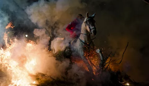 epaselect epa11829412 A rider on a horse goes through a bonfire during the 'luminarias' festival in San Bertolome de Pinares, Avila, Spain, 16 January 2025. In this centuries-old town tradition, riders guide their horses through street bonfires in a purification ritual. The practice emerged from medieval beliefs about smoke's protective powers during plague times, though we now know better disease prevention methods were needed. EPA/RAUL SANCHIDRIAN