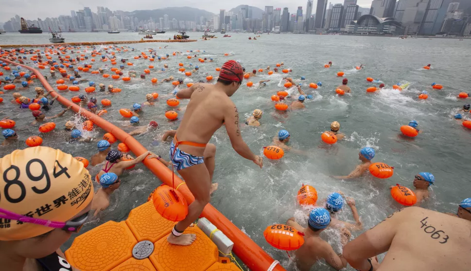 epa07108488 Competitors take part in the annual Hong Kong Cross Harbour Swim in Tsim Sha Tsui, Kowloon, Hong Kong, China, 21 October 2018. Around 3,600 participants swam from the Tsim Sha Tsui public pier in Kowloon to the Golden Bauhinia Square public pier in Wan Chai on Hong Kong Island. EPA/ALEX HOFFORD