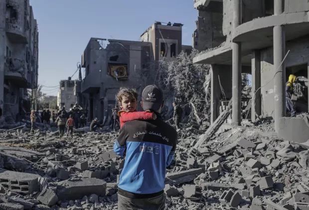 epa11803411 A Palestinian father carries his daughter next to the destroyed house of the Abu Libda family following an Israeli air strike in Al Maghazi refugee camp, central Gaza Strip, 03 January 2025. According to reports from the Ministry of Health in Gaza at least nine members of the Abu Libda family were killed following an Israeli air strike in the refugee camp. More than 45,500 Palestinians and over 1,400 Israelis have been killed, according to the Palestinian Health Ministry and the Israeli Army, since Hamas militants launched an attack against Israel from the Gaza Strip on 07 October 2023 and the Israeli operations in Gaza and the West Bank that followed it. EPA/MOHAMMED SABER