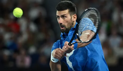 epa11841865 Novak Djokovic of Serbia plays a backhand during his Men's Singles quarterfinal match against Carlos Alcaraz of Spain at the Australian Open tennis tournament in Melbourne, Australia, 21 January 2025. EPA/JOEL CARRETT AUSTRALIA AND NEW ZEALAND OUT