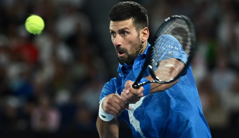 epa11841865 Novak Djokovic of Serbia plays a backhand during his Men's Singles quarterfinal match against Carlos Alcaraz of Spain at the Australian Open tennis tournament in Melbourne, Australia, 21 January 2025. EPA/JOEL CARRETT AUSTRALIA AND NEW ZEALAND OUT