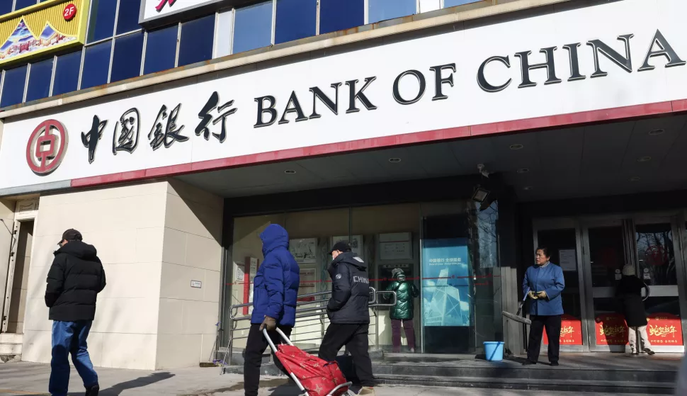 epa11837653 People walk past a bank in Beijing, China, 20 January 2025. China's one-year loan prime rate held at 3.1 percent, while the five-year benchmark loan rate was retained at 3.6 percent in January, the People's Bank of China said. EPA/WU HAO