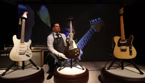 epa11823649 A Christie's auction house staff holds a Gibson solid body electric guitar that belonged to British guitarist Jeff Beck (1944-2023) during a preview of the Jeff Beck - The Guitar Collection sale at Christie's auction house in London, Britain, 14 January 2025. Beck's guitar collection is up for auction in London on 22 January 2025. EPA/ANDY RAIN