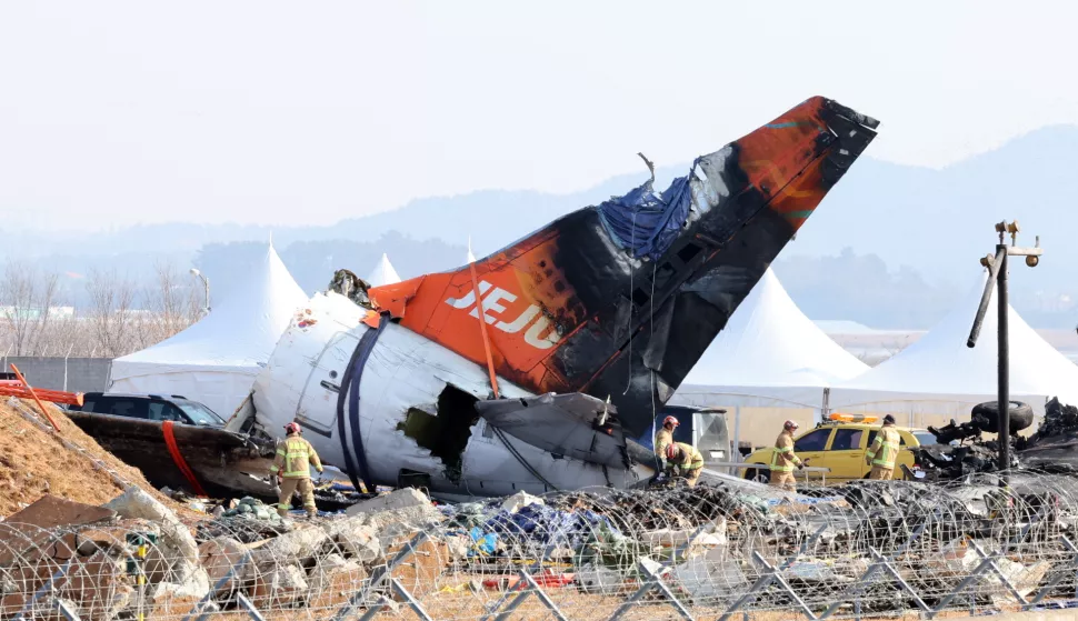 epa11821383 Firefighters remove tarpaulin sheets covering the debris of a Jeju Air passenger plane at Muan International Airport in Muan, southwestern South Korea, 13 January 2025, following its crash on 29 December 2024. EPA/YONHAP SOUTH KOREA OUT