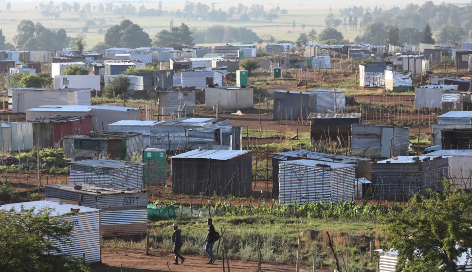 epa07222848 People walk to work through some of the new shacks that have been built illegally on land grabbed by both South African and foreign nationals in Lenasia, Johannesburg, South Africa, 11 December 2018. The in balance in land ownership in the country, with the vast majority of land still being owned by the minority white population, will be addressed during 2019 after the National Assembly voted in favor of setting up a committee to amend section 25 of the Constitution. EPA/KIM LUDBROOK