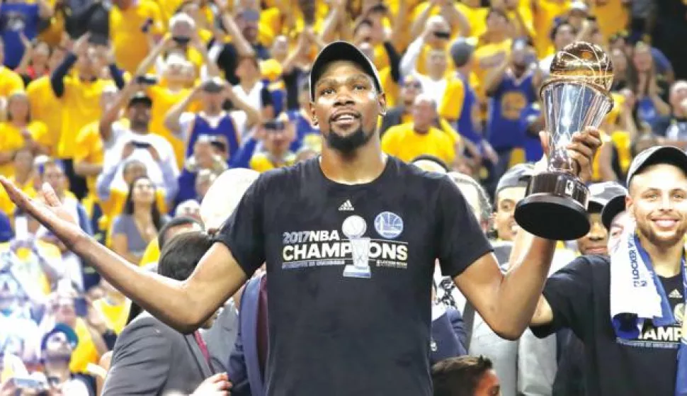 epa06025338 Golden State Warriors player Kevin Durant holds the MVP trophy while celebrating after winning the NBA Finals against the Cleveland Cavaliers in game five of the NBA Finals basketball game at Oracle Arena in Oakland, California, USA, 12 June 2017. EPA/LARRY W. SMITH