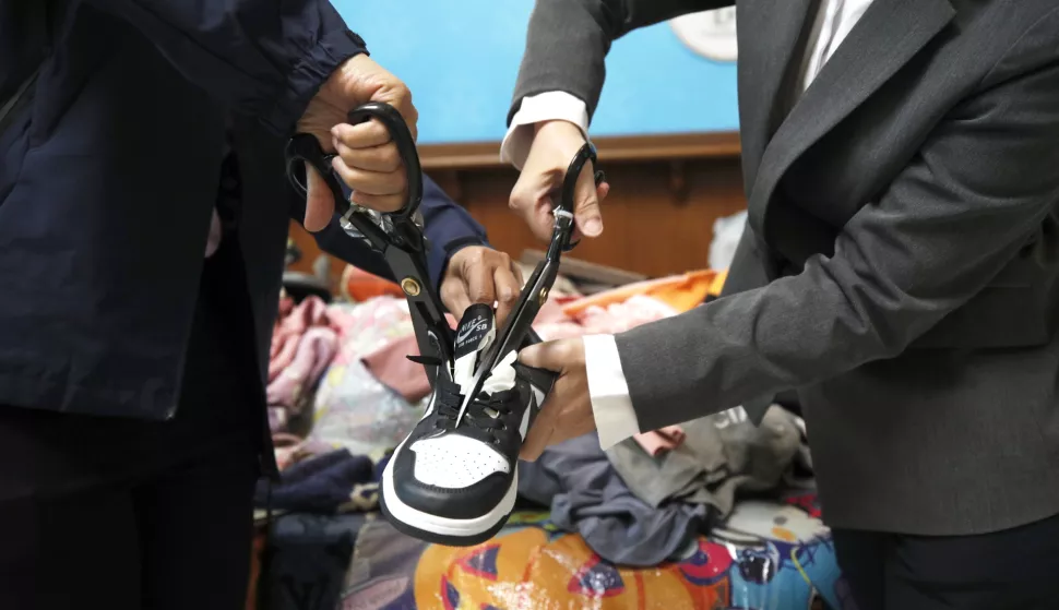 epa11903988 Thai customs officials use scissors to cut and destroy a seized counterfeit fashion footwear during an intellectual property rights infringement goods destruction press conference at the Customs Department in Bangkok, Thailand, 18 February 2025. According to the Thai Customs Department, 602,600 counterfeit and pirated goods worth 46 million baht (1.3 million euros), including clothes, handbags, and footwear, will be destroyed. These items were seized in raids to combat trademark infringement. EPA/RUNGROJ YONGRIT