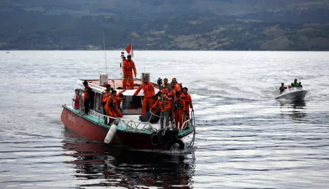 epa06824761 Indonesian rescue team members carry the body of a victim on a boat near Tigaras Port, Simalungun, North Sumatra, Indonesia, 20 June 2018. A ferry carrying some 185 passengers capsized at Lake Toba killing at least three persons. An estimated 18 people were rescued as over a hundred remain missing, media reported. EPA/ADI RICHAD