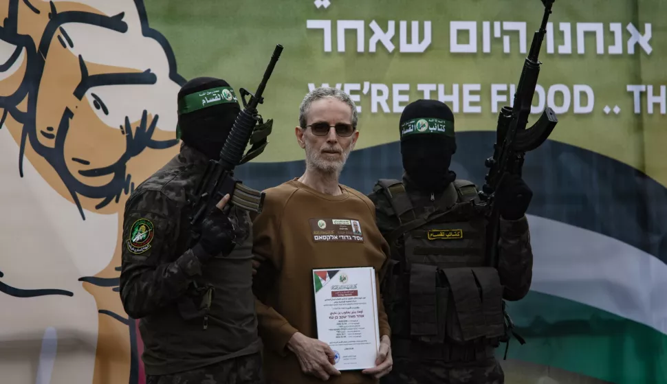 epaselect epa11882145 Palestinian fighters from Hamas's Izz ad-Din al-Qassam Brigades escort Israeli hostages Ohad Ben-Ami (pictured), Or Levi and Eli Sharabi onto the stage before handing them over to a Red Cross team in Deir al-Balah, central Gaza, 08 February 2025. In exchange, Israel will release 183 Palestinian prisoners and detainees. EPA/HAITHAM IMAD