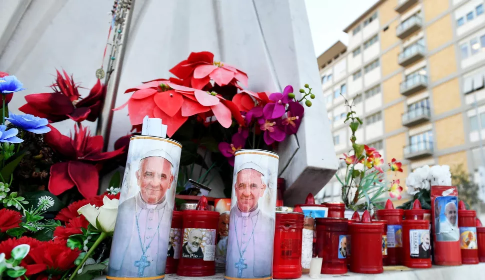 epa11912070 Flowers and candles lay at the foot of a statue of Pope St. John Paul II outside Gemelli University Hospital, where Pope Francis is hospitalized for bronchitis treatment, in Rome, Italy, 21 February 2025. Pope Francis was hospitalized on 14 February due to a respiratory tract infection. EPA/FABIO CIMAGLIA