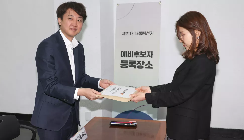 epa12017015 Lee Jun-seok (L), a lawmaker of the minor opposition New Reform Party, submits his application for registration as a preliminary candidate for a presidential election to an official at the National Election Commission in Gwacheon, South Korea, 08 April 2025. South Korea is preparing for an early vote after the ouster of President Yoon Suk Yeol, with the date for the election being 03 June. EPA/YONHAP SOUTH KOREA OUT