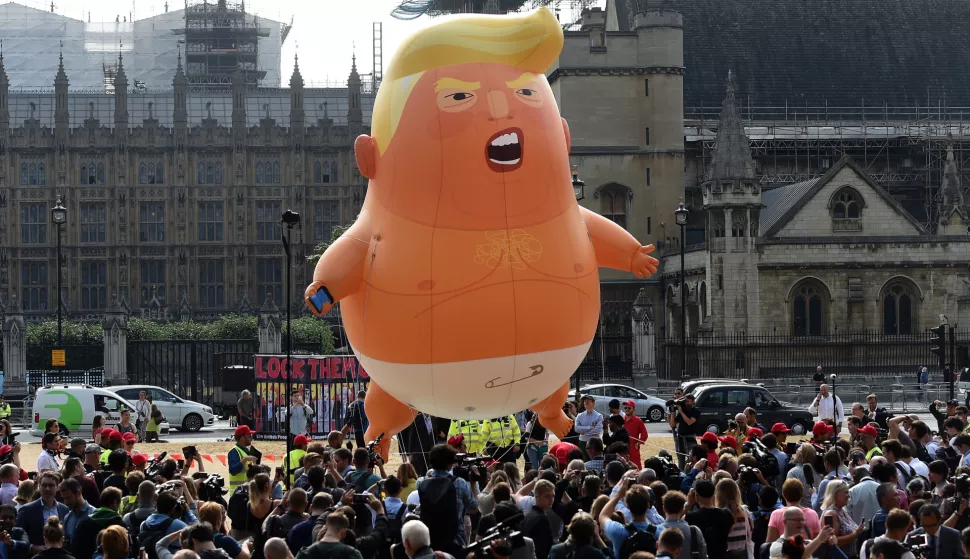 epa06885212 The 'Donald Trump Baby Blimp' balloon flies over Parliament Square during a protest in London, Britain, 13 July 2018. The inflatable dubbed 'Trump Baby' tied to a spot in Parliament Square is to kick off a day of protests against US President Donald J. Trump's visit. Trump is on a working visit to Britain. EPA/ANDY RAIN