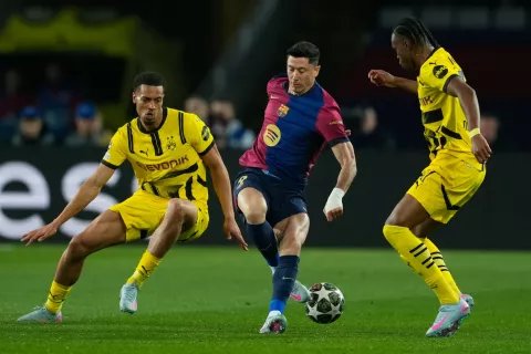 epa12021251 Barcelona's Robert Lewandowski (C) in action against Borussia's Carney Chukwuemeka (R) during the UEFA Champions League quarter-final first leg match between FC Barcelona and Borussia Dortmund at the Estadio Olimpico Lluis Companys in Barcelona, Spain, 09 April 2025. EPA/Alejandro Garcia