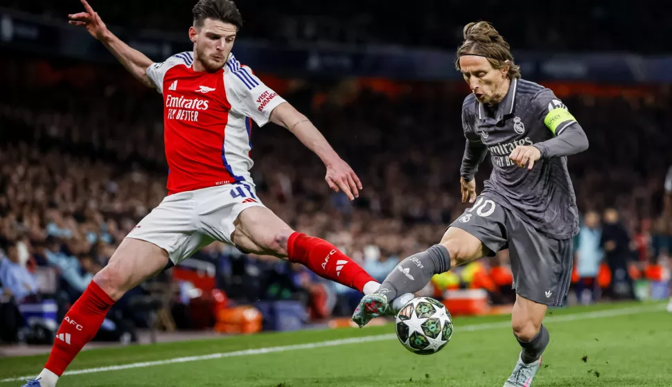 epa12018874 Declan Rice of Arsenal (L) in action against Luka Modric of Real Madrid (R) during the UEFA Champions League quarter-final 1st leg match between Arsenal FC and Real Madrid in London, Britain, 08 April 2025. EPA/TOLGA AKMEN