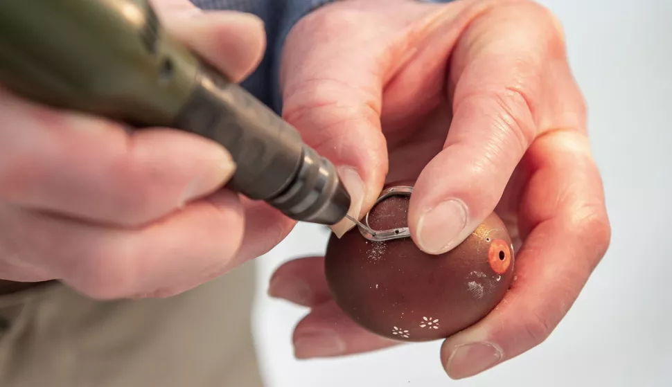 epa12036808 Craftsman Gyula Laszlo decorates an Easter egg with a tiny horseshoe by carefully nailing it to the shell in the Mives Eggs Museum in Zengovarkony, Hungary, 17 April 2025. EPA/Tamas Kacsur HUNGARY OUT
