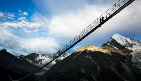 epa06116061 People walk on the 'Europabruecke' bridge, the world's longest pedestrian suspension bridge with a length of 494m, after the official inauguration of the construction in Randa, Switzerland, 29 July 2017. The bridge is situated on the Europaweg that connects the villages of Zermatt and Graechen. EPA/VALENTIN FLAURAUD
