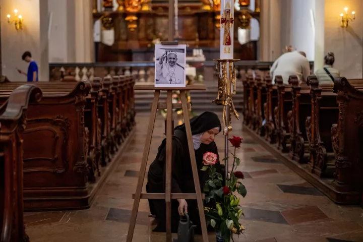 epa12046229 A nun adjusts flowers placed next to a portrait of the late Pope Francis in the Church of Our Lady Victorious in Prague, Czech Republic, 22 April 2025. Pope Francis died on 21 April 2025 at the age of 88, according to the Holy See. Born Jorge Mario Bergoglio in Buenos Aires, Argentina, on 17 December 1936, he was appointed leader of the Catholic Church on 13 March 2013, succeeding Pontiff Emeritus Benedict XVI. EPA/MARTIN DIVISEK