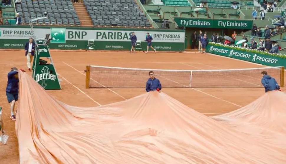 epa06789249 The court is covered as Rafael Nadal of Spain playing Diego Schwartzman of Argentina during their menâ€™s quarter final match is interrupted due to rain during the French Open tennis tournament at Roland Garros in Paris, France, 06 June 2018. EPA/CAROLINE BLUMBERG------2x color - sport