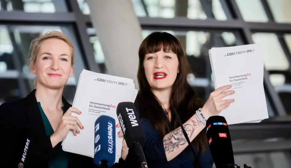 epaselect epa12020875 The Left party (Die Linke) parliamentary group co-leader Heidi Reichinnek (R) and the Left party (Die Linke) co-leader Ines Schwerdtner (L) present a coalition agreement between the CDU/CSU and SPD with a modified title in Berlin, Germany, 09 April 2025, as they speak about the coalition agreement between the CDU/CSU and SPD. Instead of reading "Responsibility for Germany" it states "Irresponsible for Germany". EPA/CHRISTOPH SOEDER