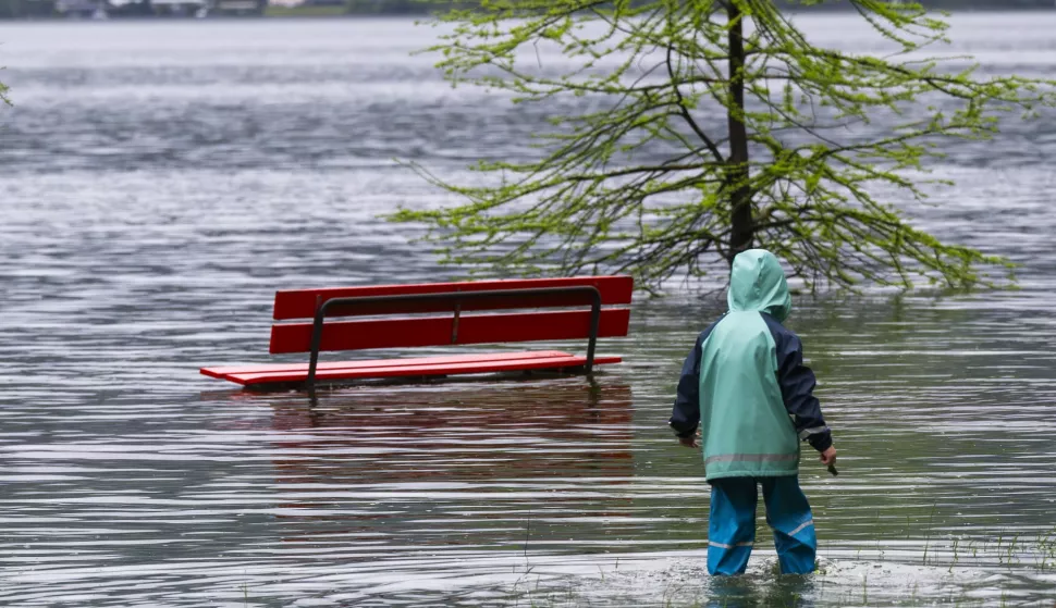 epa12036749 A child walk next to the overflowing River Maggia due to heavy rainfall in Tegna (Terre di Pedemonte), Switzerland, 17 April 2025. EPA/SAMUEL GOLAY