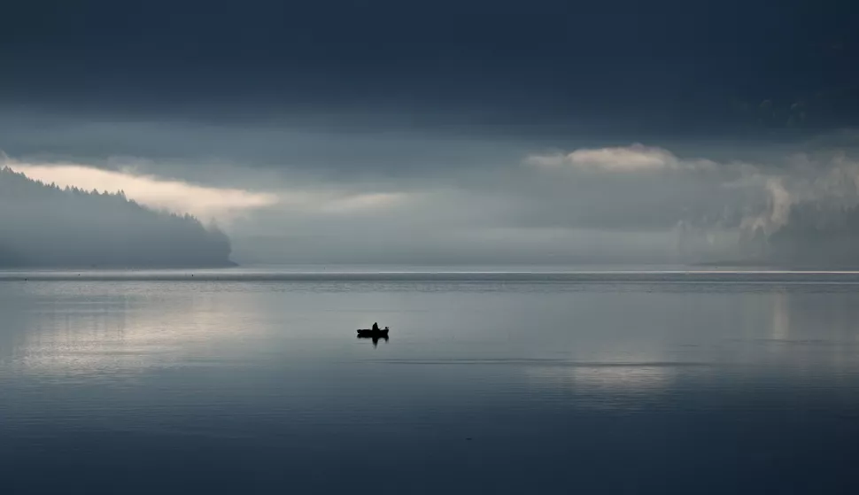 epa12061758 A fisherman in their boat at the lake Walchensee, which has very low water level at this time, in Kochel, Bavaria, Germany, 29 April 2025. EPA/ANNA SZILAGYI