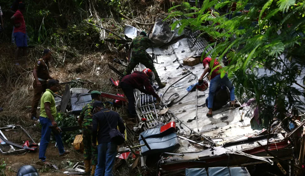 epa12090551 People and rescue workers gather near the debris of a passenger bus that plunged into a precipice in Kotmale, Sri Lanka, 11 May 2025. According to officials, more than 20 people were killed and several others injured after a Sri Lanka Transport Board (SLTB) passenger bus plunged into a precipice in the central hill country area of Kotmale. EPA/STRINGER