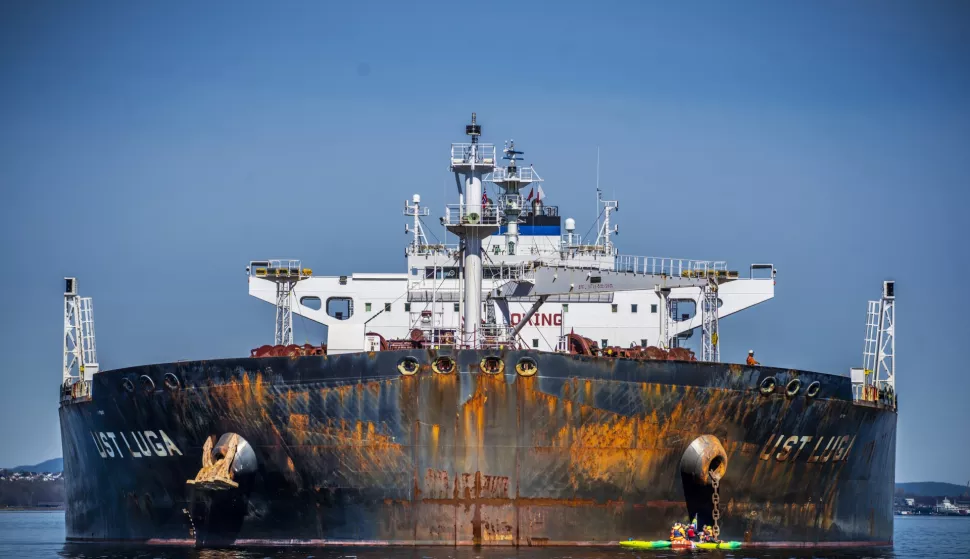 epa09908180 Greenpeace activists in a small rubber dinghy sail close to the anchor chain of the Russian oil tanker ship 'Ust Luga' during a protest on Asgardstrand, close to Oslo, Norway, 25 April 2022. Greenpeace activists blocked an unloading of oil delivered by the Russian tanker ship as part of a protest against Russian invasion of Ukraine. EPA/OLE BERG-RUSTEN NORWAY OUT